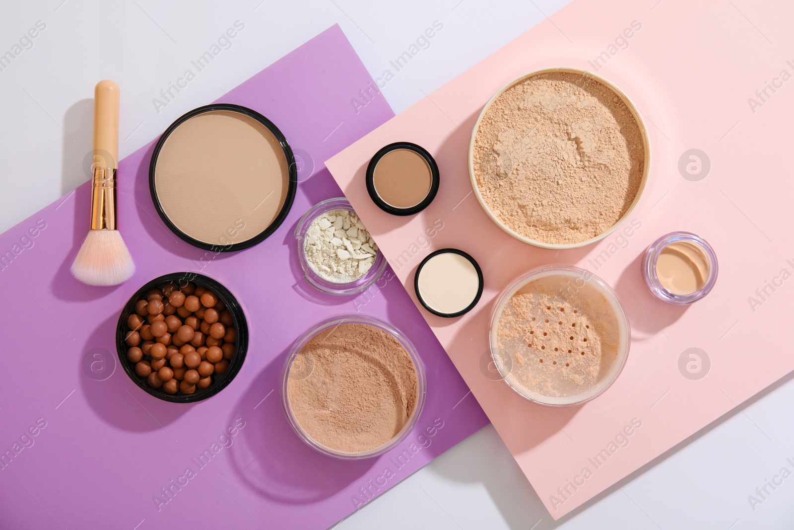 Photo of Flat lay composition with various makeup face powders on color background