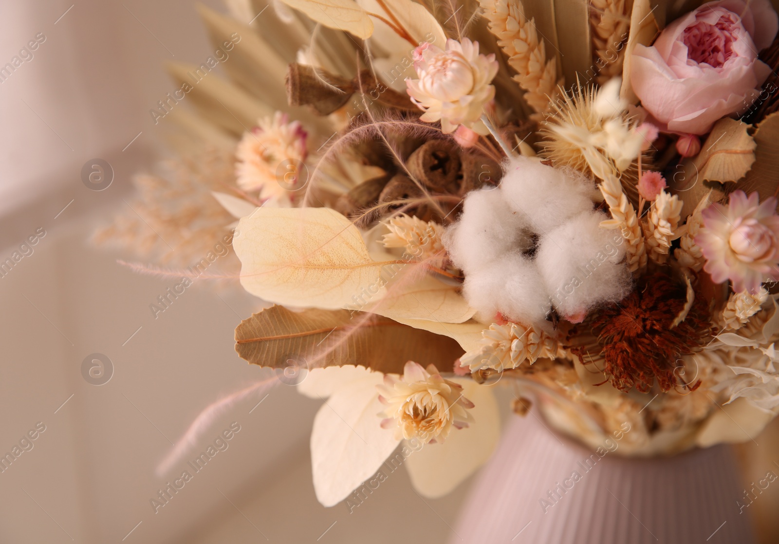 Photo of Bouquet of dry flowers and leaves on blurred background, closeup
