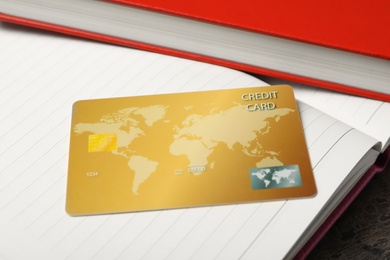 Credit card and open notebook on table, closeup