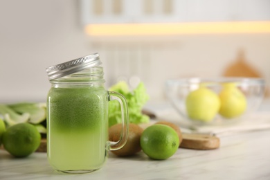 Photo of Tasty fresh juice in mason jar on table indoors. Space for text