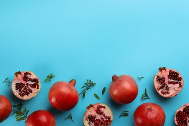 Photo of Flat lay composition with ripe pomegranates on light blue background. Space for text
