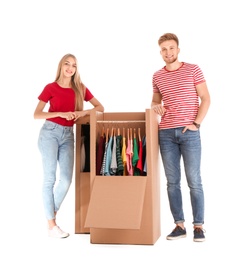 Young couple near wardrobe boxes on white background