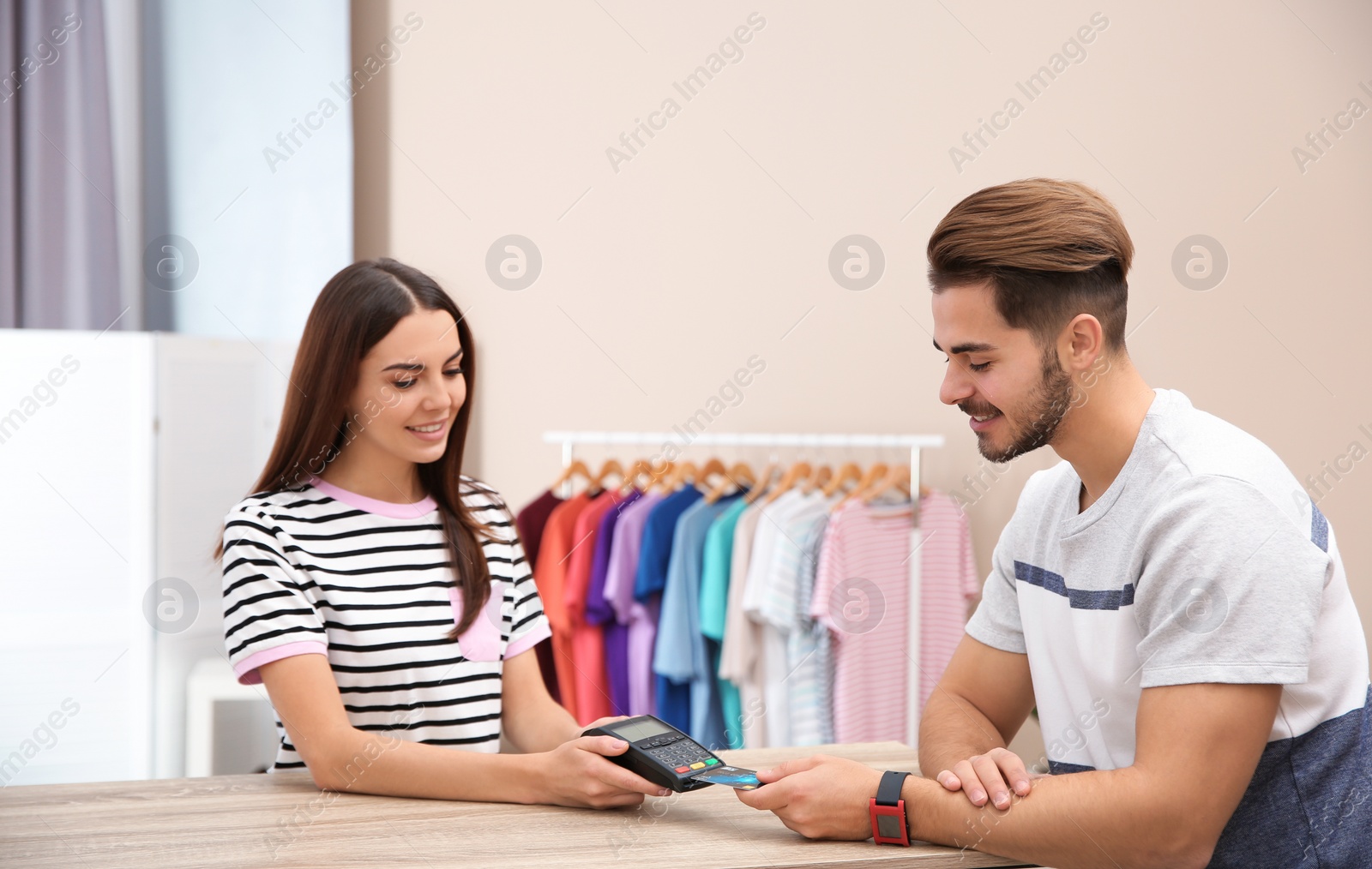 Photo of Man using terminal for credit card payment in shop