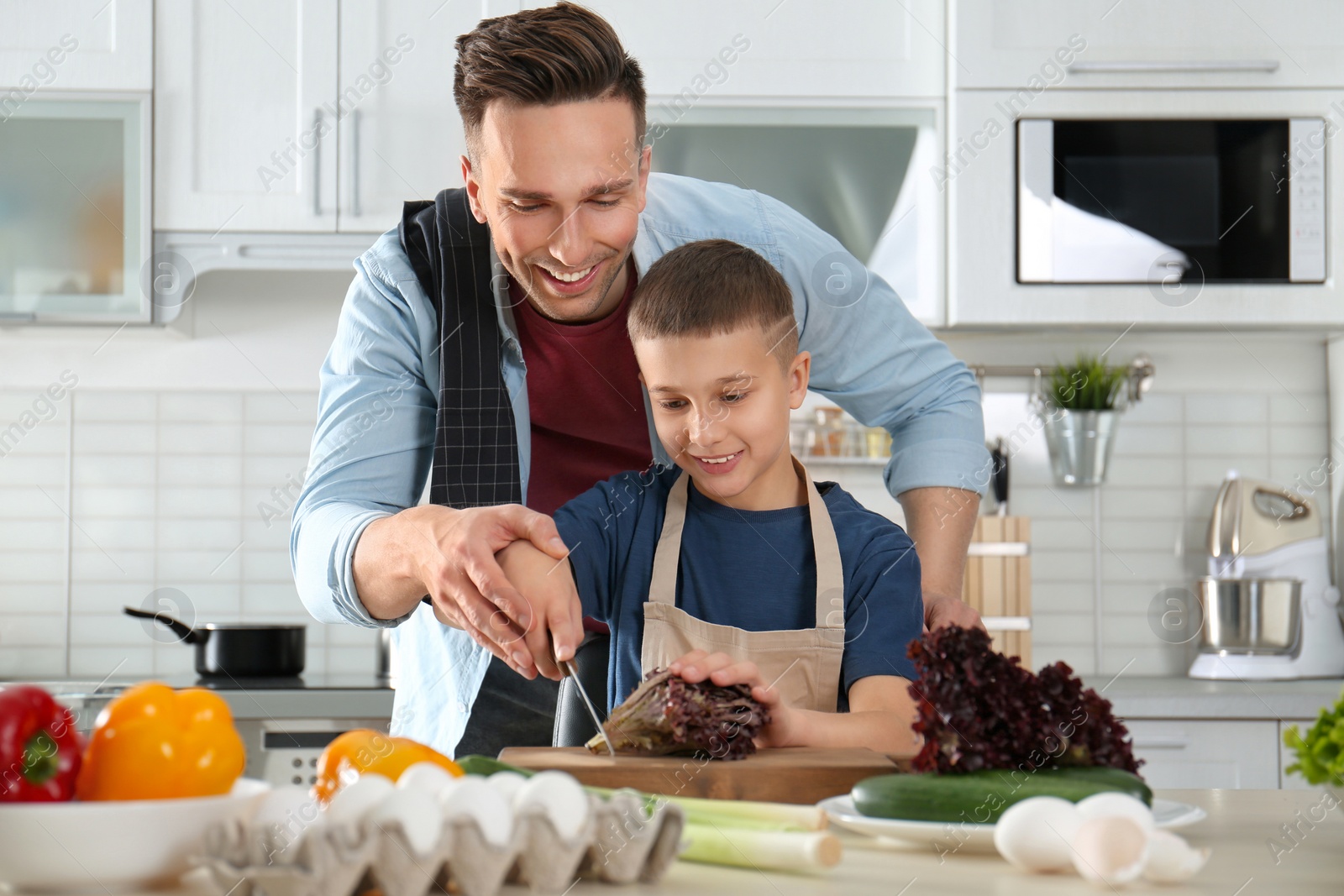 Photo of Dad and son cooking together in kitchen