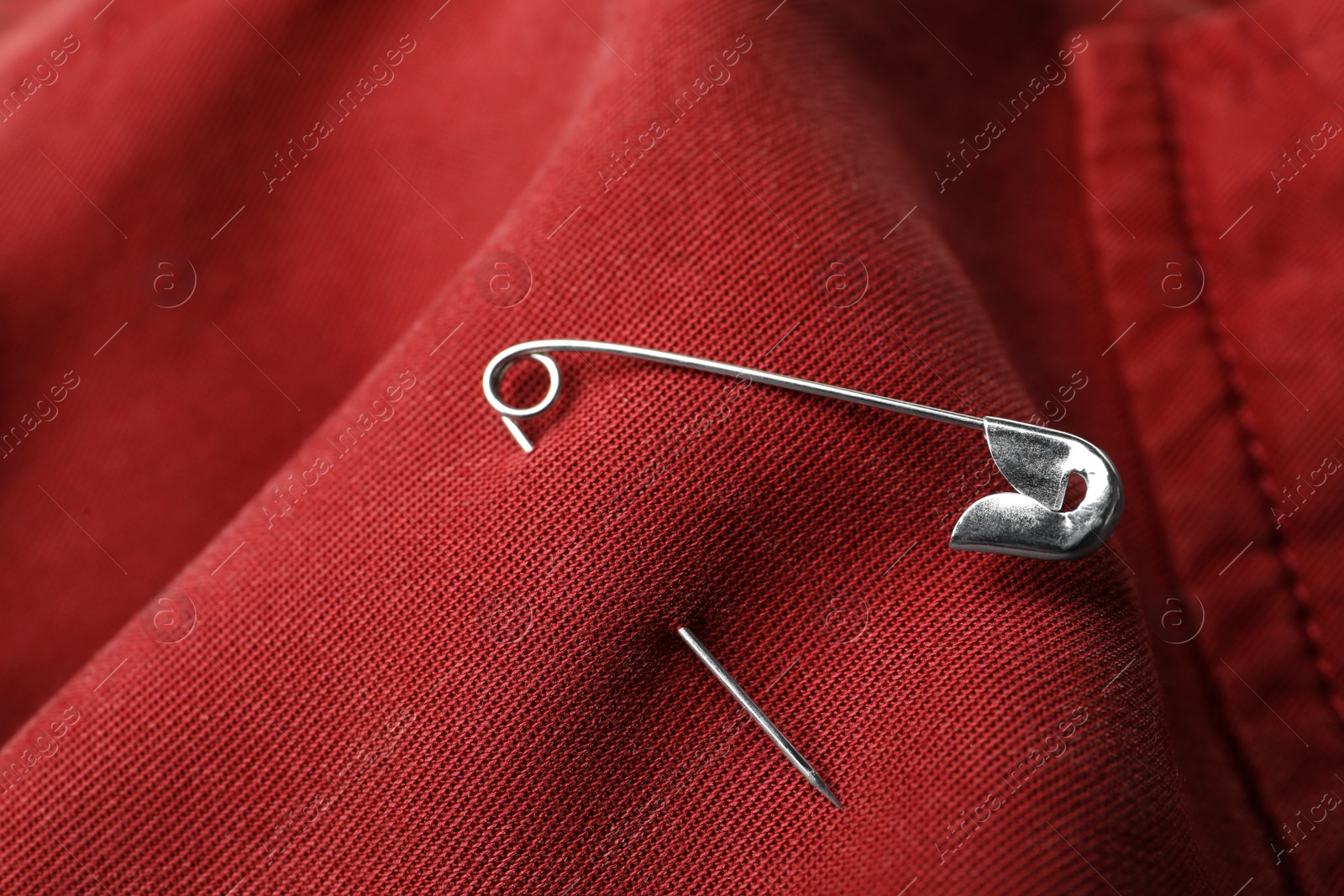 Photo of Closeup view of metal safety pin on clothing