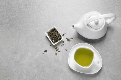 Photo of Flat lay composition with green tea on grey background. Space for text