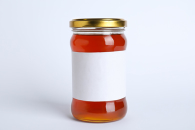 Photo of Glass jar of wildflower honey with blank label isolated on white