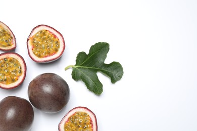 Photo of Fresh ripe passion fruits (maracuyas) with leaf on white background, flat lay. Space for text