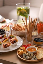 Photo of Dishes with different food on table in living room. Luxury brunch