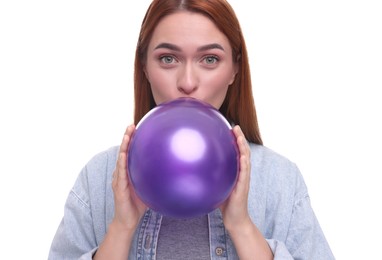 Woman inflating purple balloon on white background