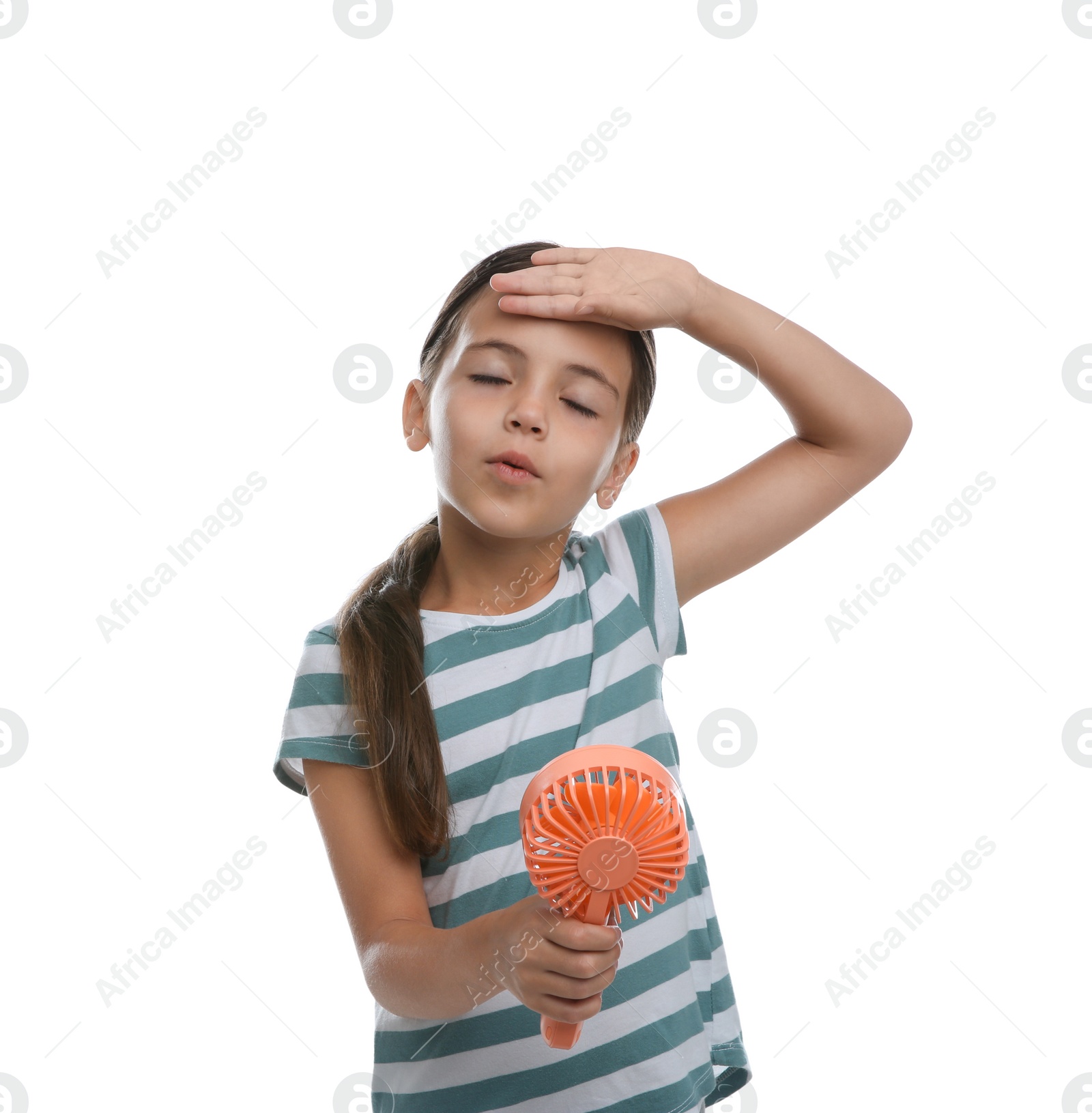 Photo of Little girl with portable fan suffering from heat on white background. Summer season