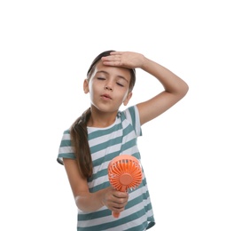 Photo of Little girl with portable fan suffering from heat on white background. Summer season