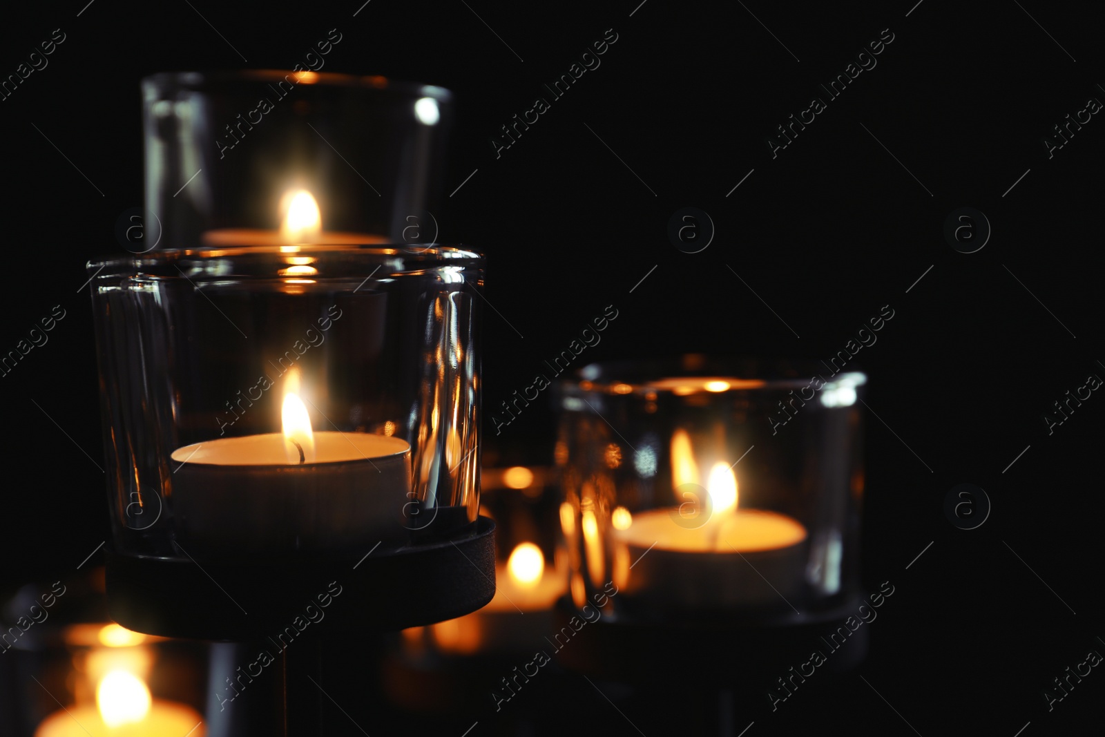 Photo of Burning candles on dark background. Funeral symbol