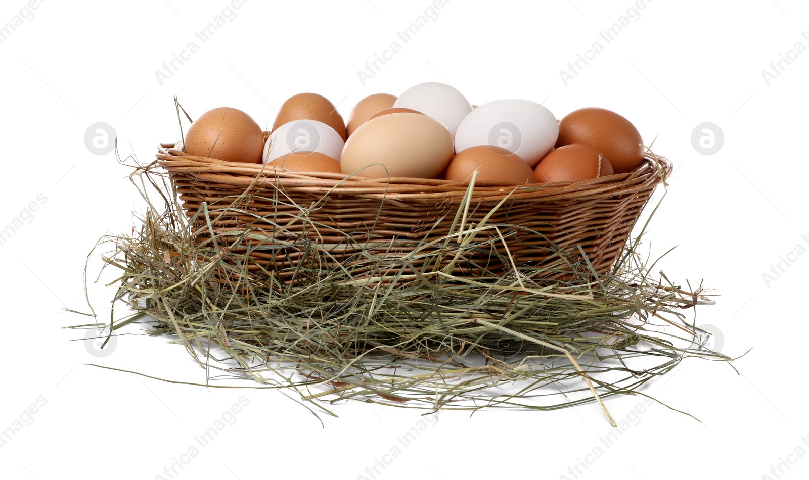 Photo of Fresh chicken eggs in wicker basket and dried hay isolated on white