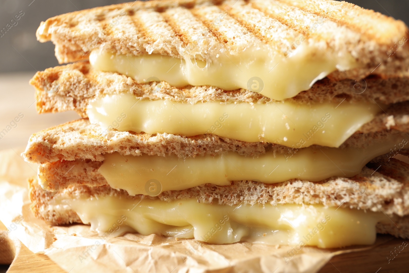 Image of Tasty toast sandwiches with cheese on table, closeup