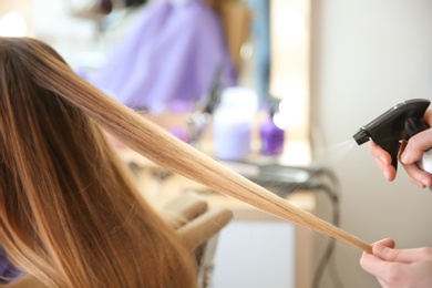 Photo of Professional hairdresser working with client in salon