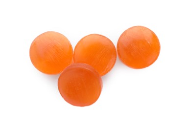 Photo of Orange cough drops on white background, top view