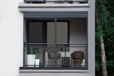 Photo of Wicker chairs and green plants on balcony