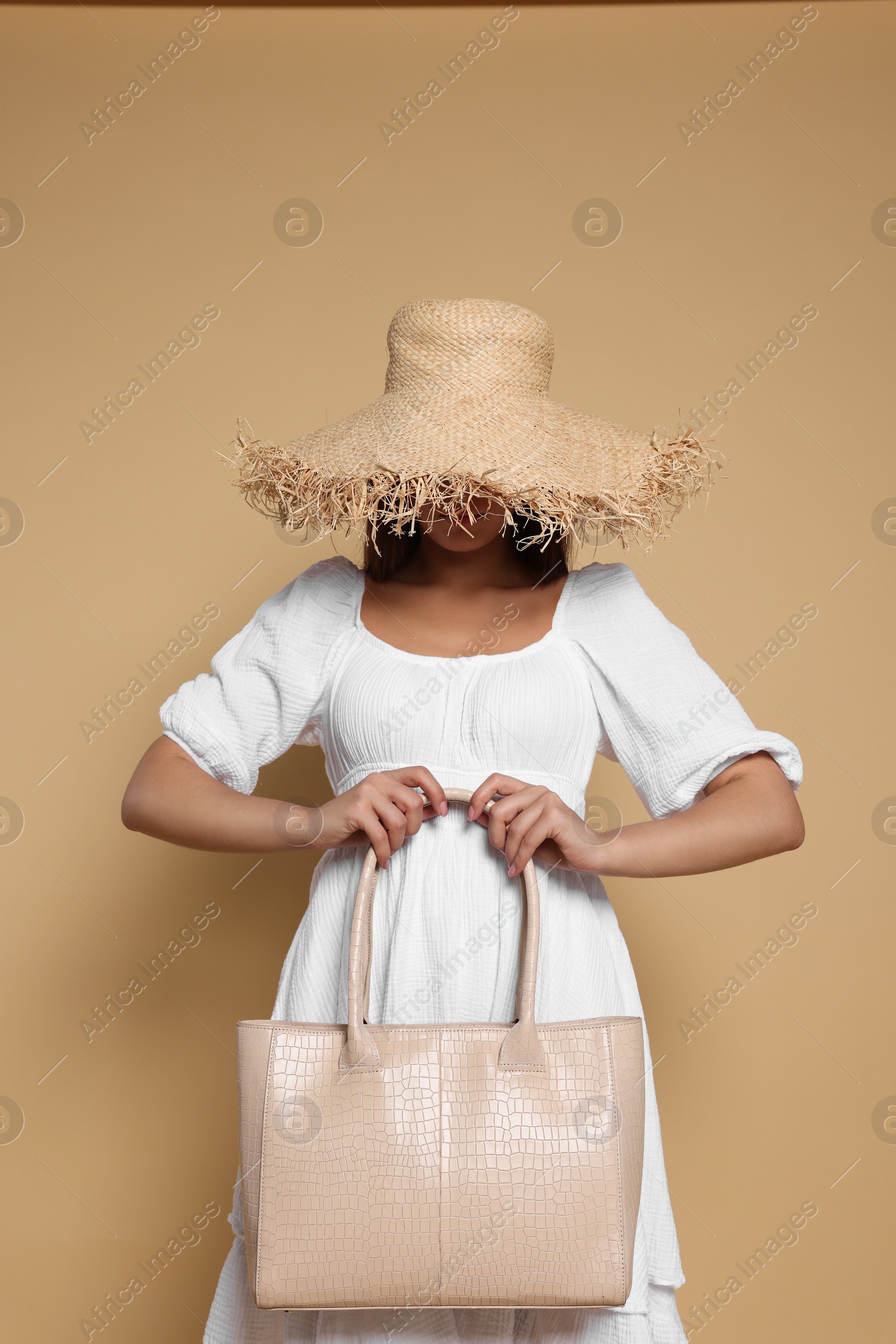 Photo of Young woman with stylish bag on beige background