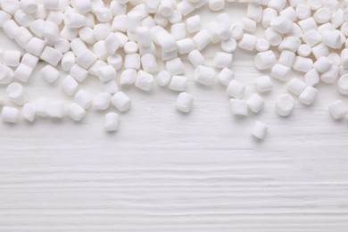 Photo of Delicious marshmallows on white wooden table, flat lay