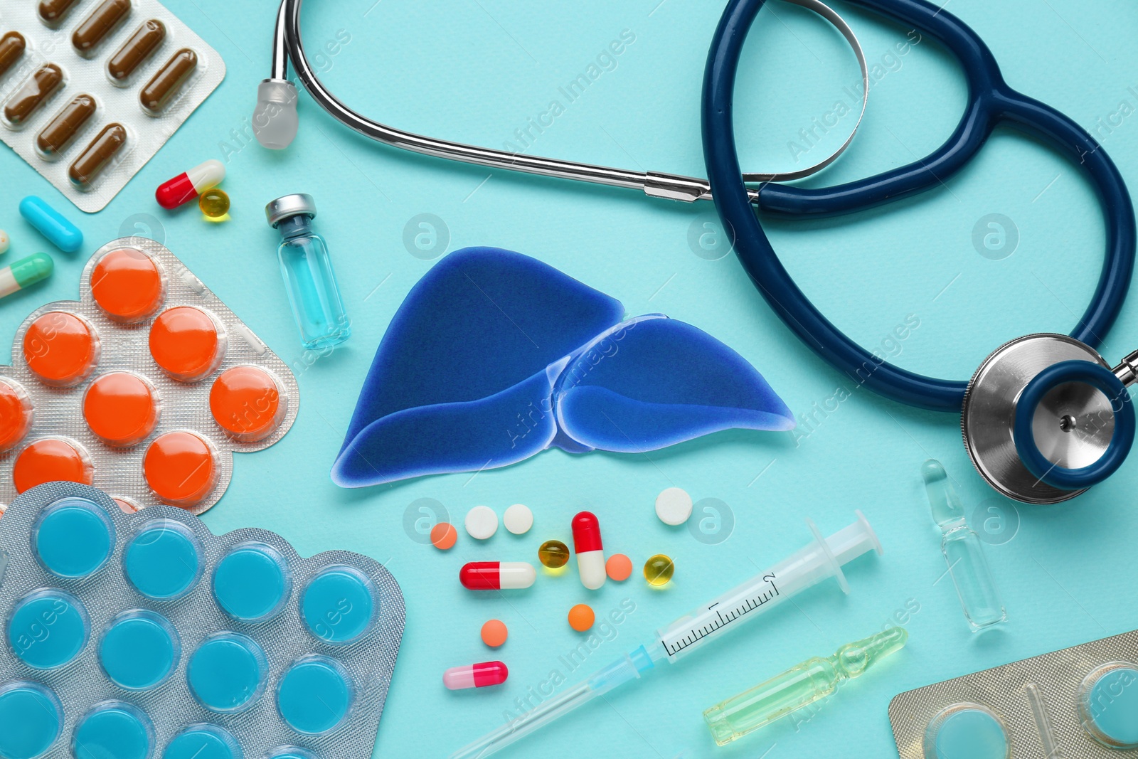 Photo of Paper liver and medical supplies on turquoise background, flat lay. Hepatitis treatment