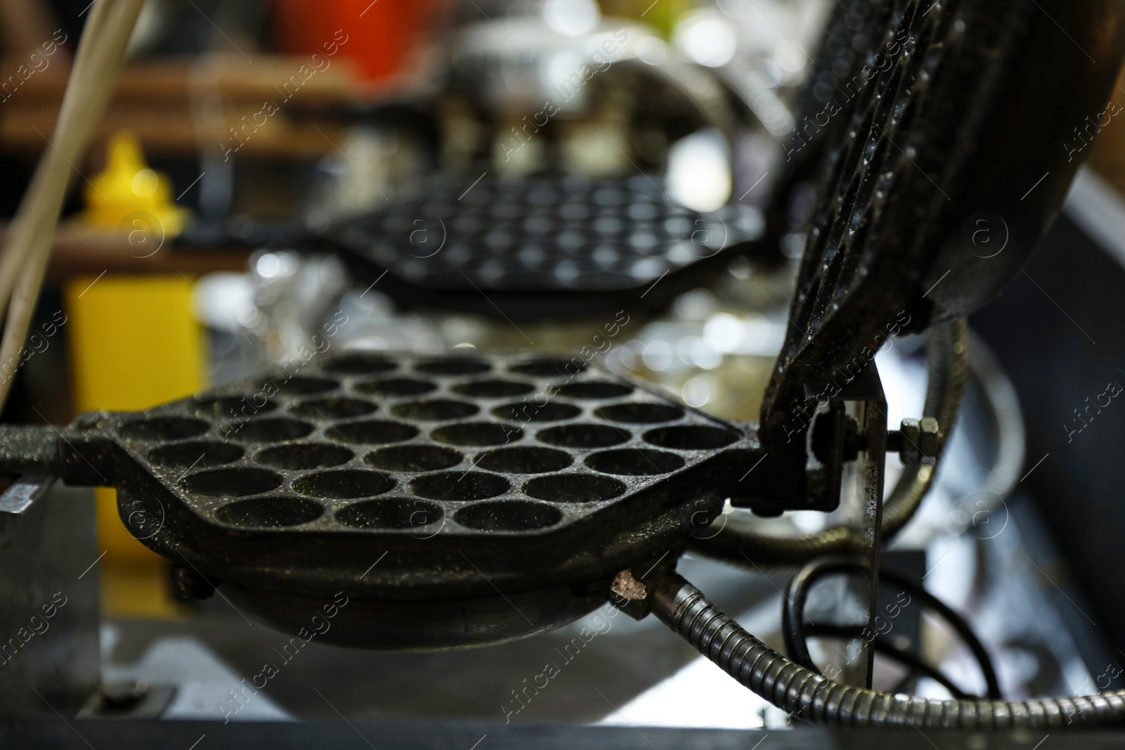 Photo of Modern waffle iron on table against blurred background