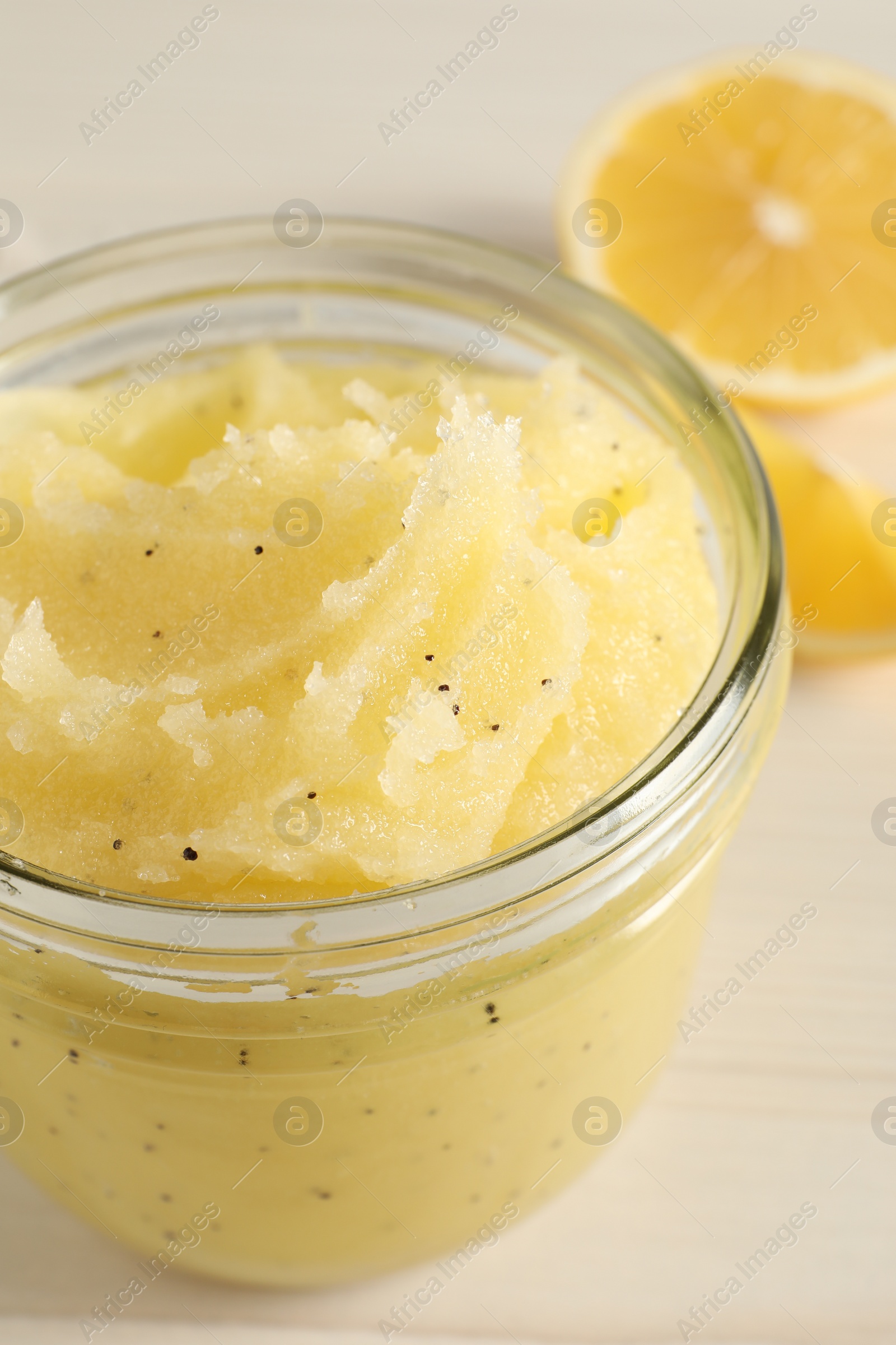 Photo of Body scrub in glass jar on light table, closeup