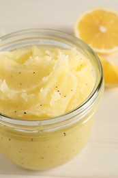 Photo of Body scrub in glass jar on light table, closeup