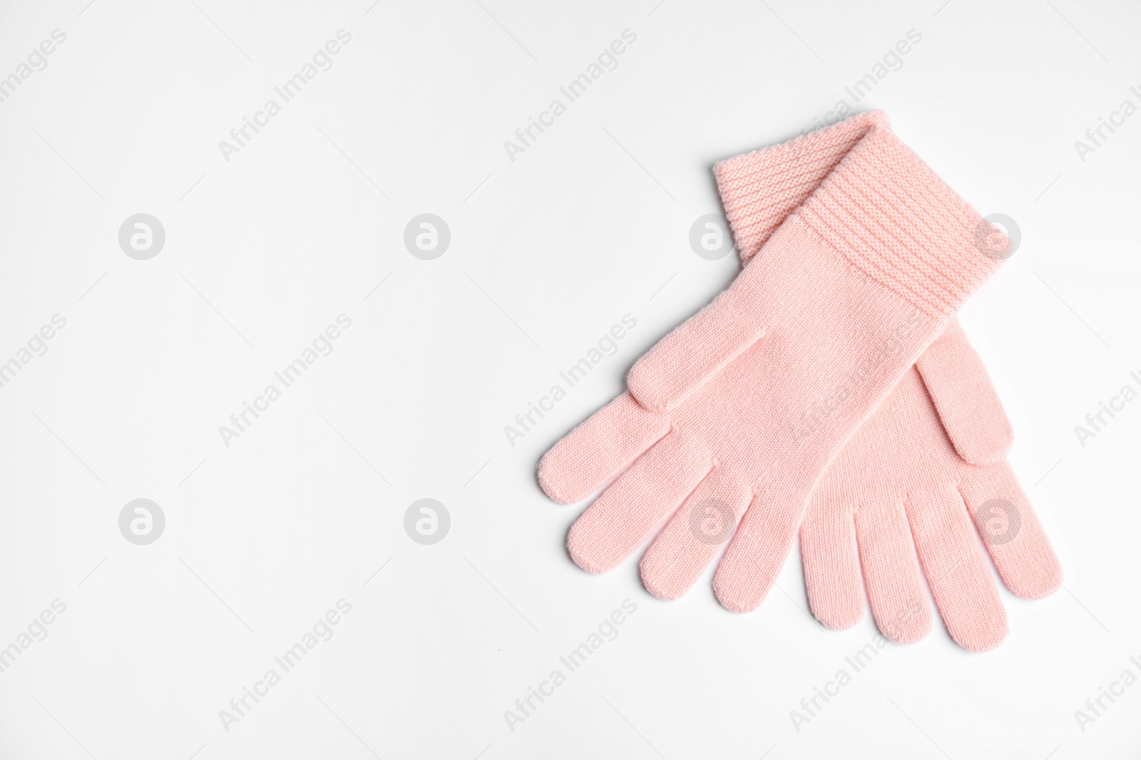 Photo of Stylish pink gloves on white background, top view with space for text. Autumn clothes