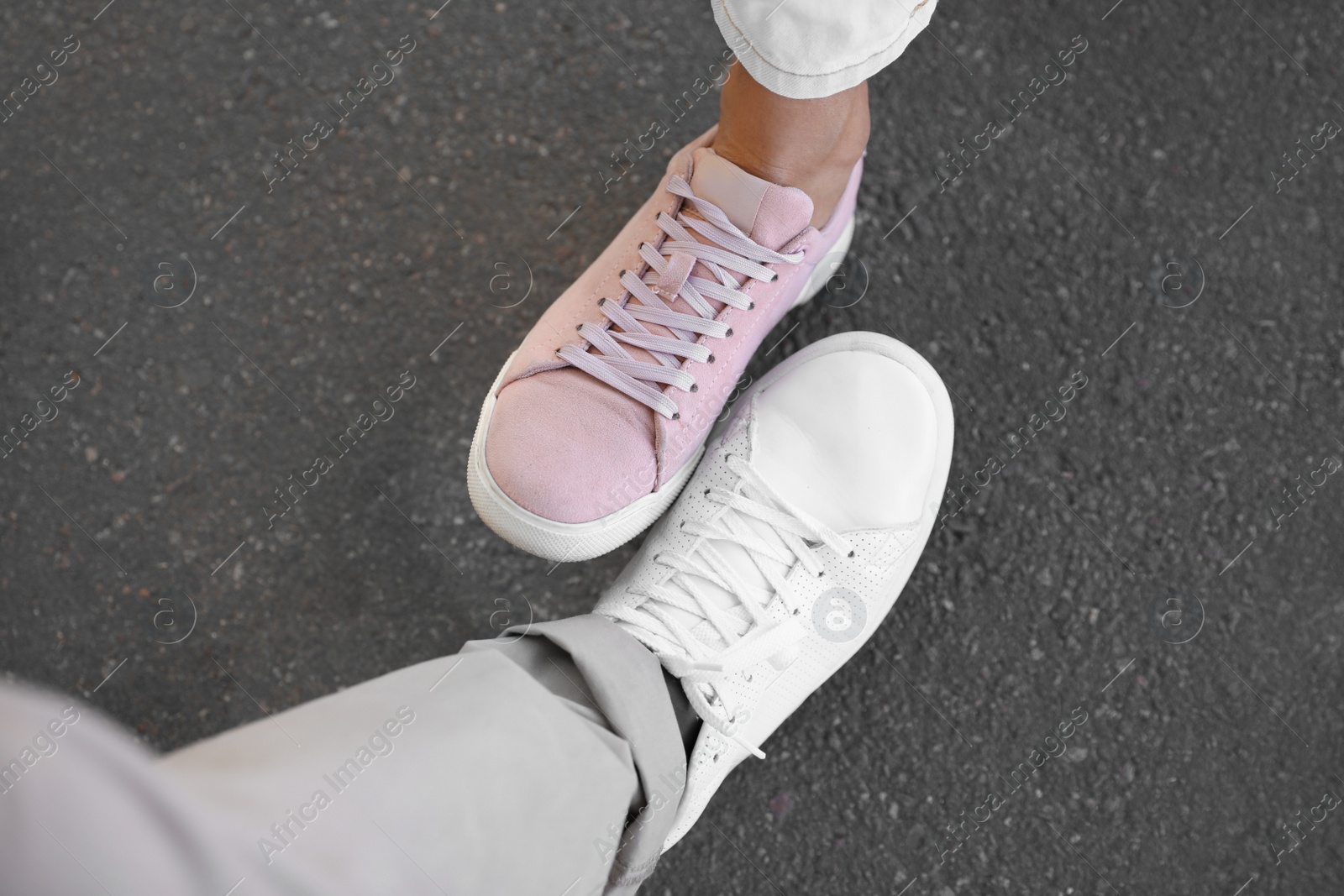 Photo of Man and woman bumping legs to say hello outdoors, closeup. Keeping social distance during coronavirus pandemic