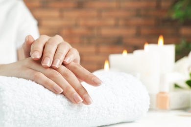 Photo of Woman showing smooth hands on towel at table, closeup with space for text. Spa treatment