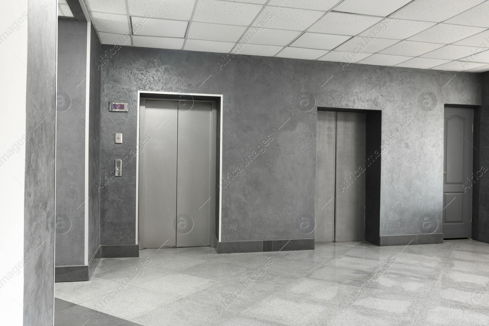 Photo of Closed stylish elevator doors in clean hall