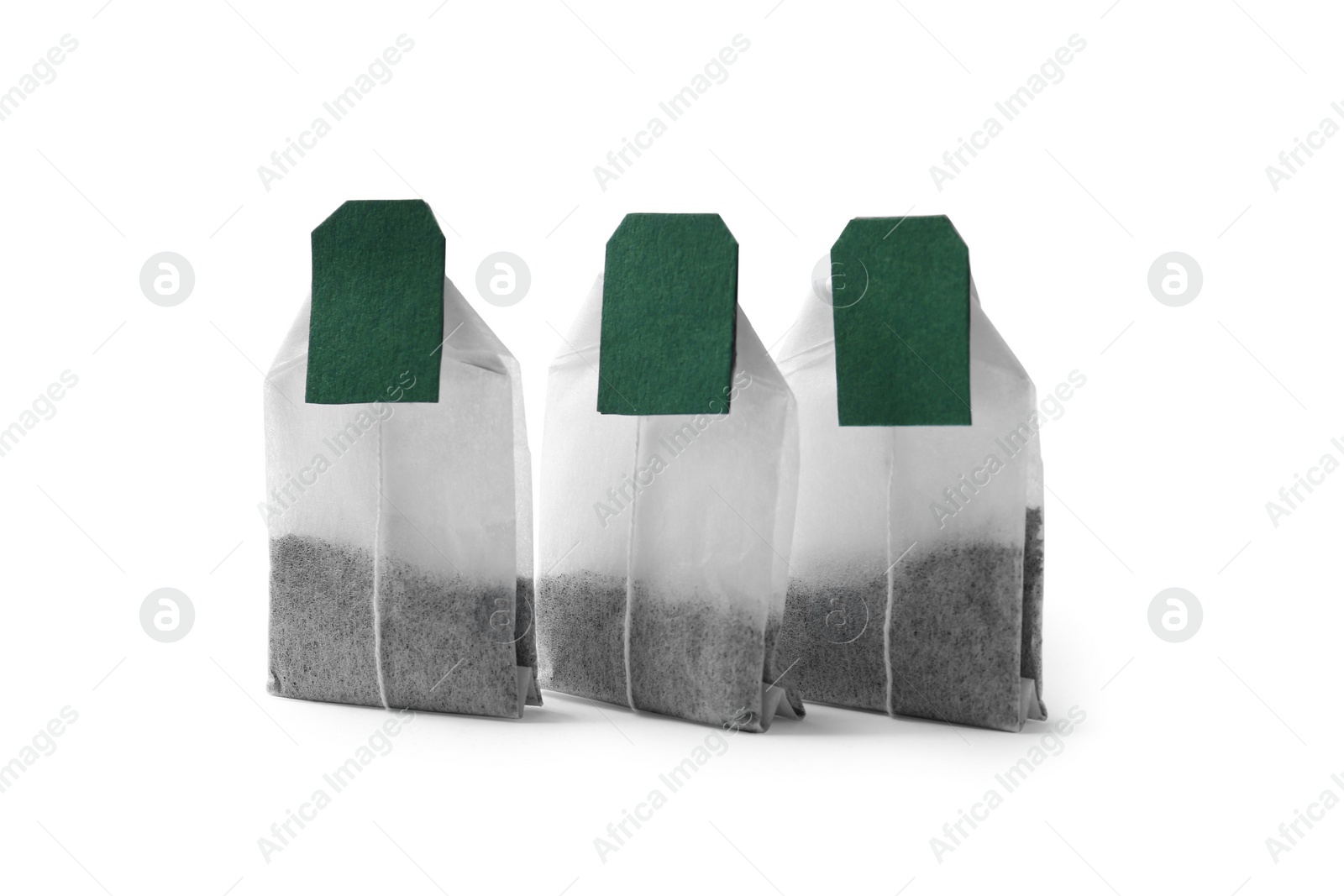 Photo of New tea bags with labels on white background