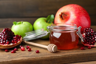 Photo of Honey, pomegranate and apples on wooden table, closeup. Rosh Hashana holiday