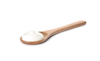 Wooden spoon with sour cream on white background