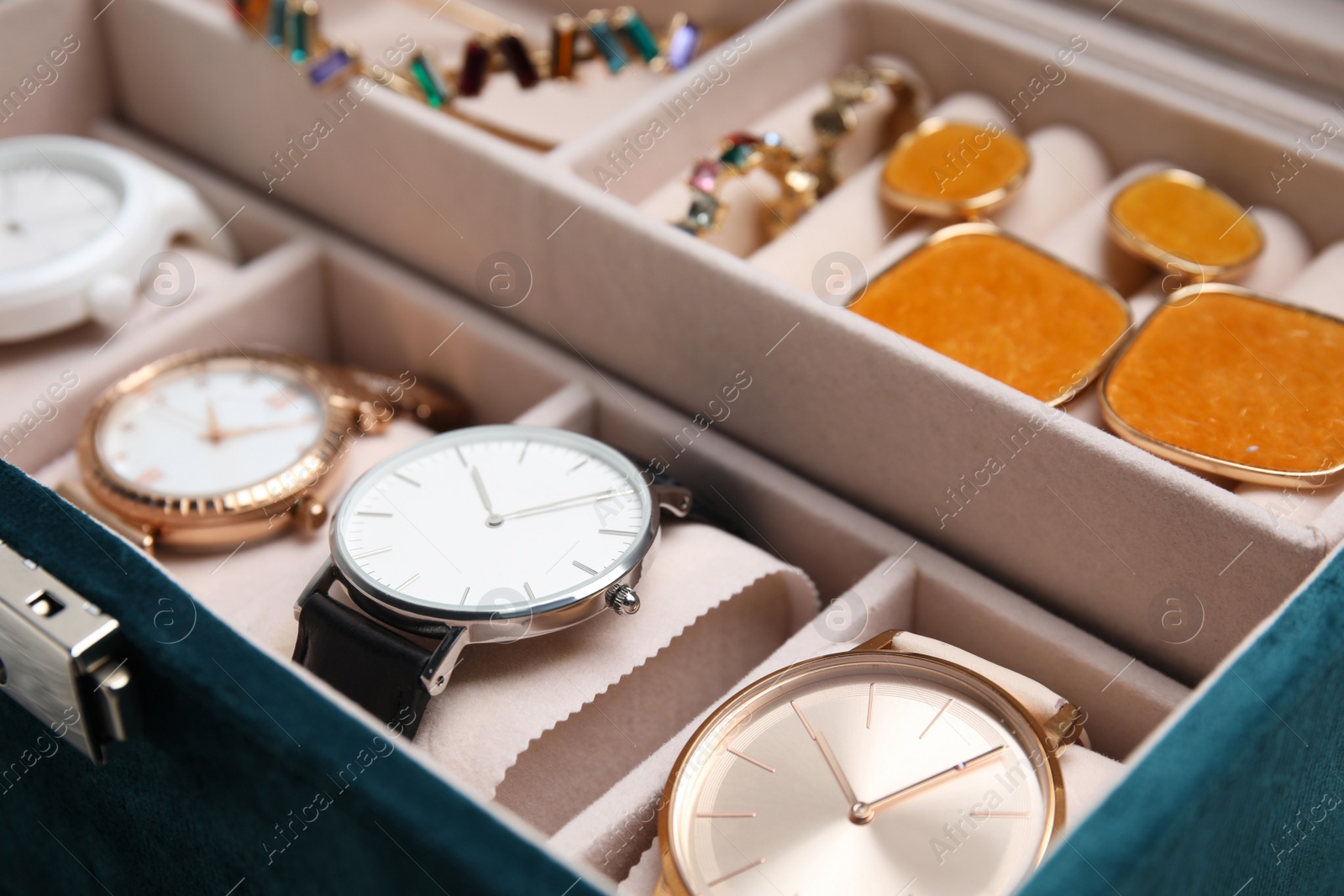 Photo of Elegant jewelry box with beautiful bijouterie and expensive wristwatches, closeup