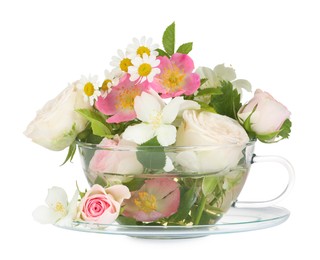 Photo of Aromatic herbal tea in glass cup with different flowers isolated on white