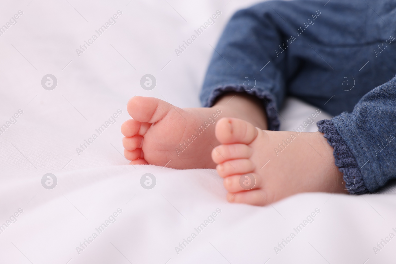 Photo of Newborn baby lying on white blanket, closeup