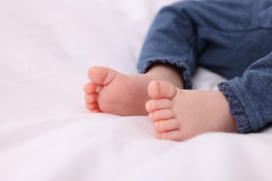 Newborn baby lying on white blanket, closeup