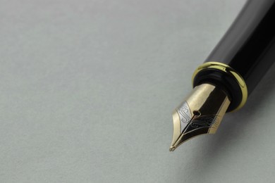 Photo of Stylish fountain pen on light grey table, closeup. Space for text
