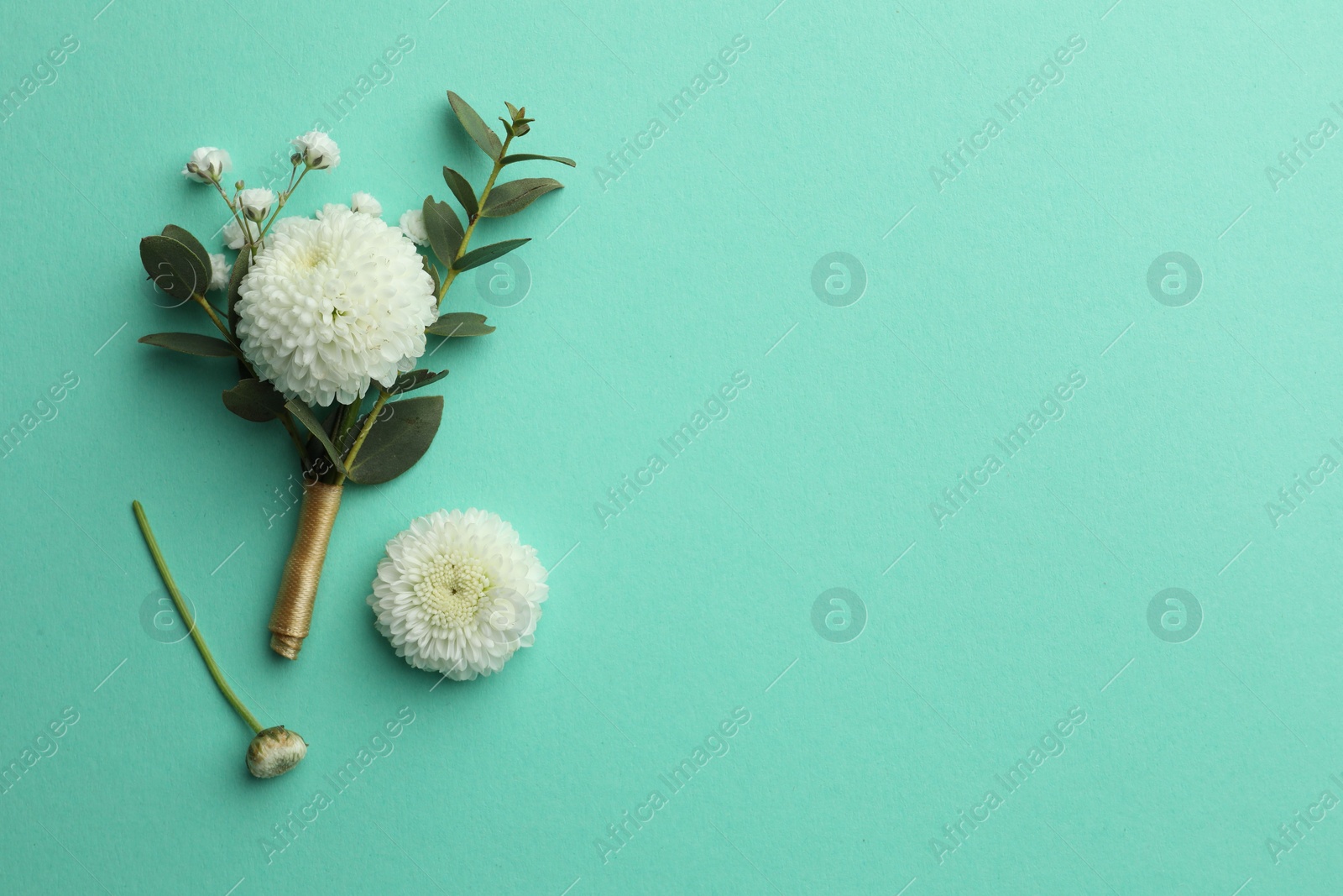 Photo of Small stylish boutonniere on turquoise background, top view. Space for text