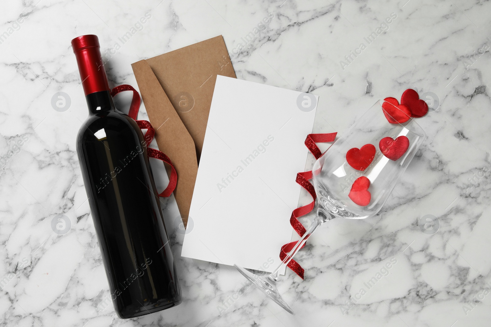 Photo of Flat lay composition with blank card on white marble table, space for text. Valentine's Day celebration