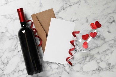 Photo of Flat lay composition with blank card on white marble table, space for text. Valentine's Day celebration