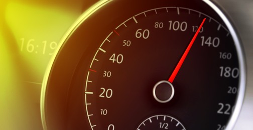 Speedometer on car dashboard under yellow light, closeup. Banner design