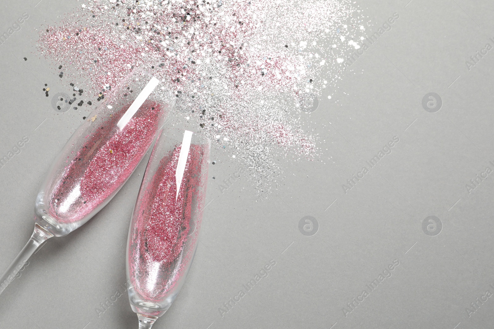 Photo of Flat lay composition with champagne glasses for celebration on grey background. Space for text