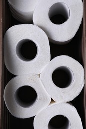 Photo of Many toilet paper rolls in crate, top view