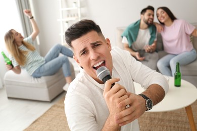 Man singing karaoke with friends at home