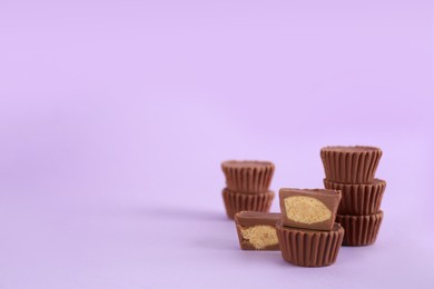 Sweet peanut butter cups on violet background. Space for text