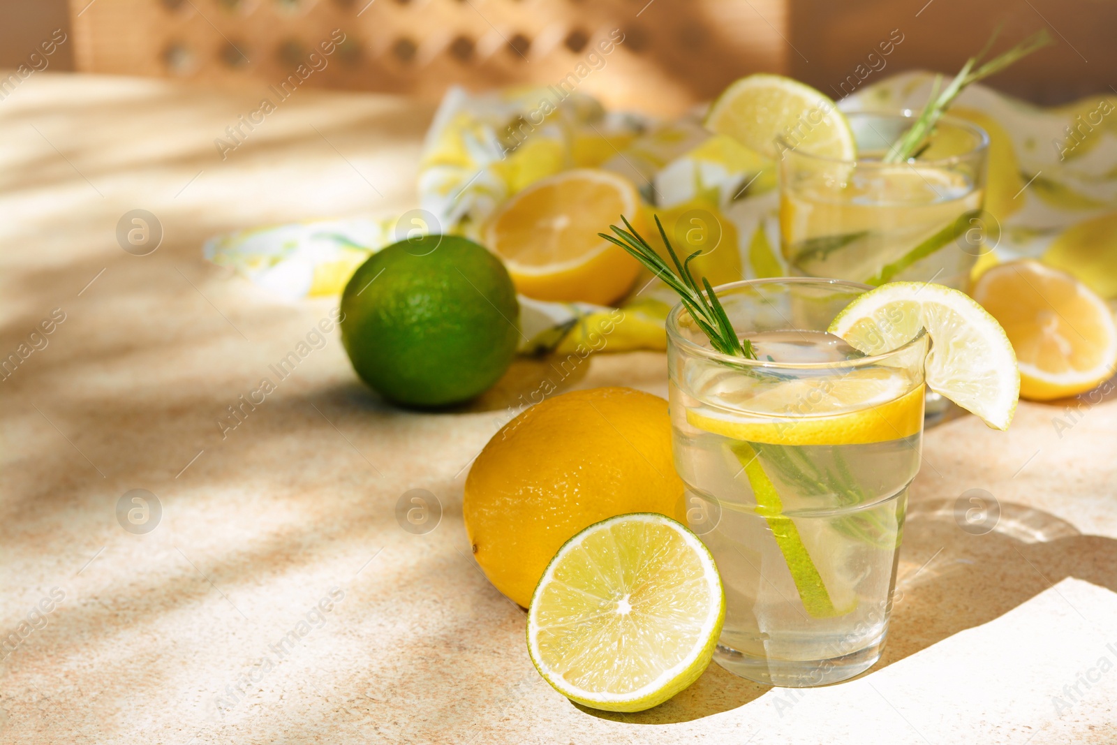 Photo of Tasty summer refreshing lemonade and ingredients on light table, space for text