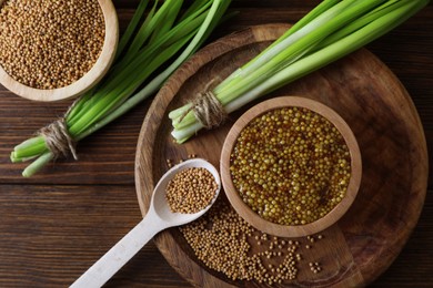 Tray with delicious whole grain mustard, seeds and fresh green onion on wooden table, flat lay